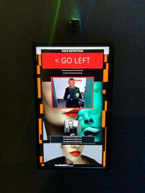 A vertical screen shows a face-recognition interface with GO LEFT, portrait images, and a green sculpted face.