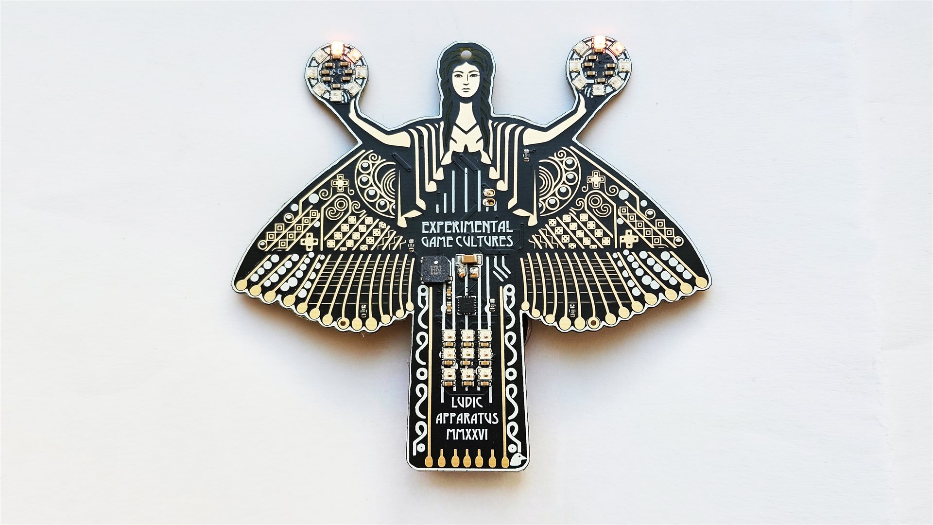Winged brooch with a central figure, patterned circuit traces, and two circular jeweled accents on a white background