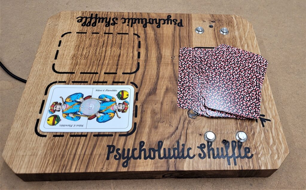 Wooden card-game board with a marked play area, a phone, a card stack, and small buttons on the right.